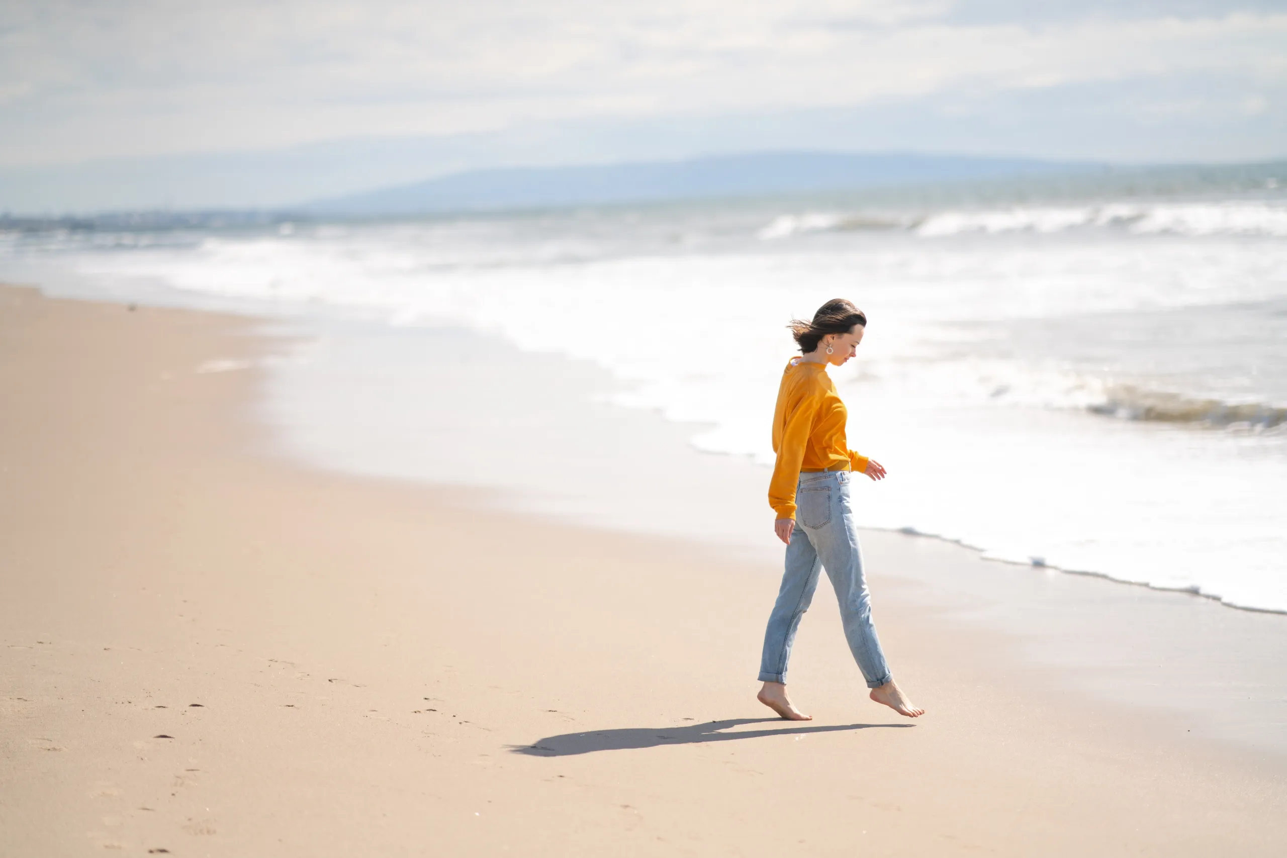 Persona paseando por la playa libre de pánico y agorafobia después de completar su tratamiento psicológico