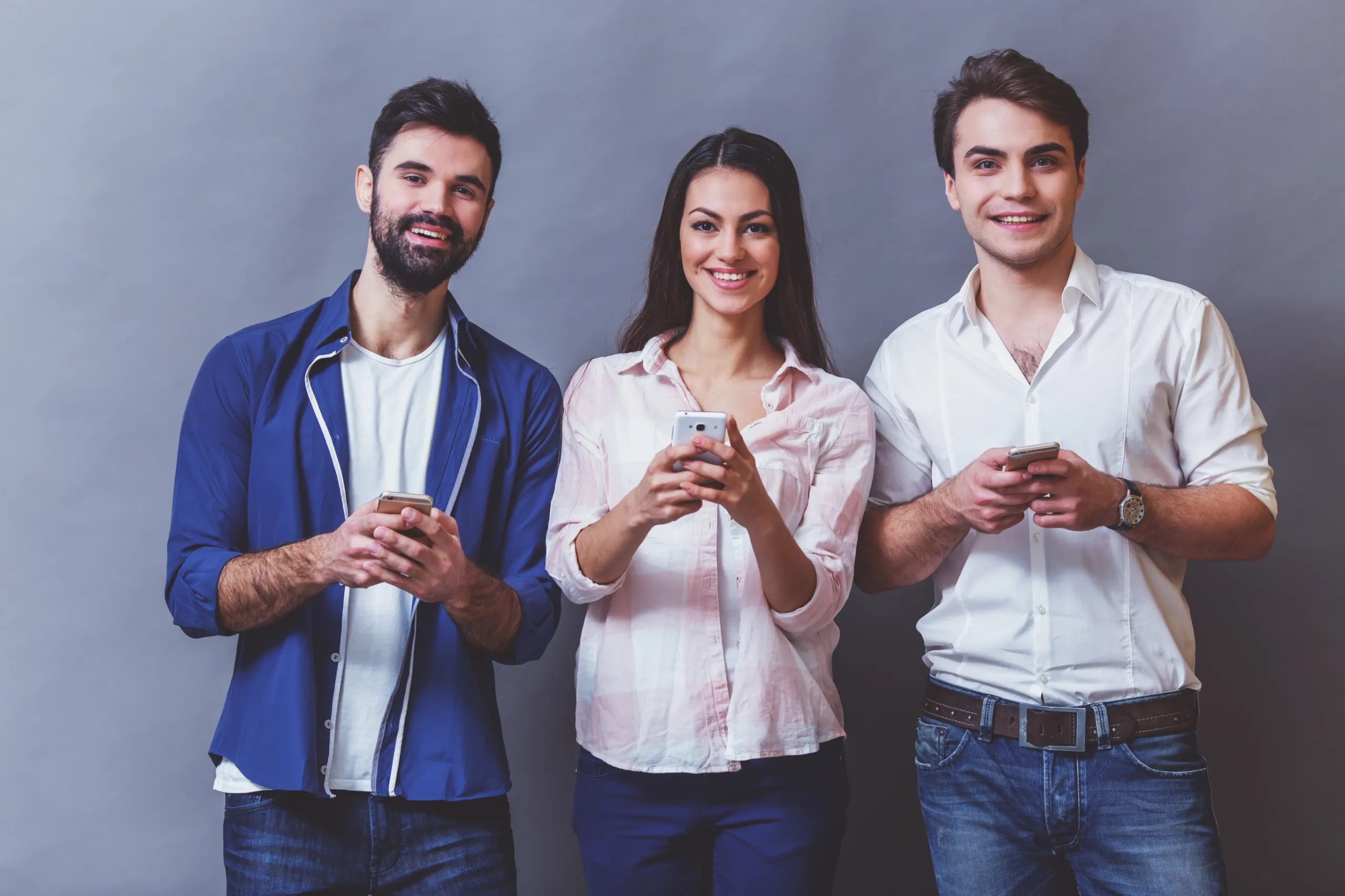 Grupo de jóvenes consultan sus teléfonos móviles para contactar con Alborán Psicólogos en Granada
