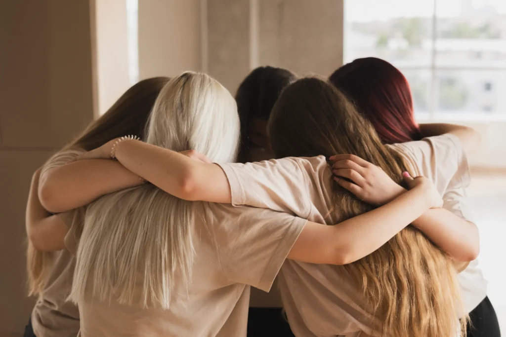Grupo de mujeres se abrazan y ofrecen apoyo unas a otras en Granada durante terapia psicológica para mujeres víctimas de violencia de género