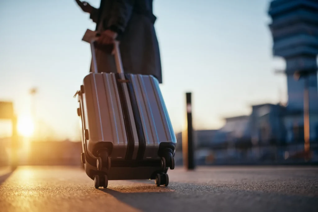 Mujer víctima de violencia de género caminando liberada con una maleta y un billete de avión después de dejar a su pareja