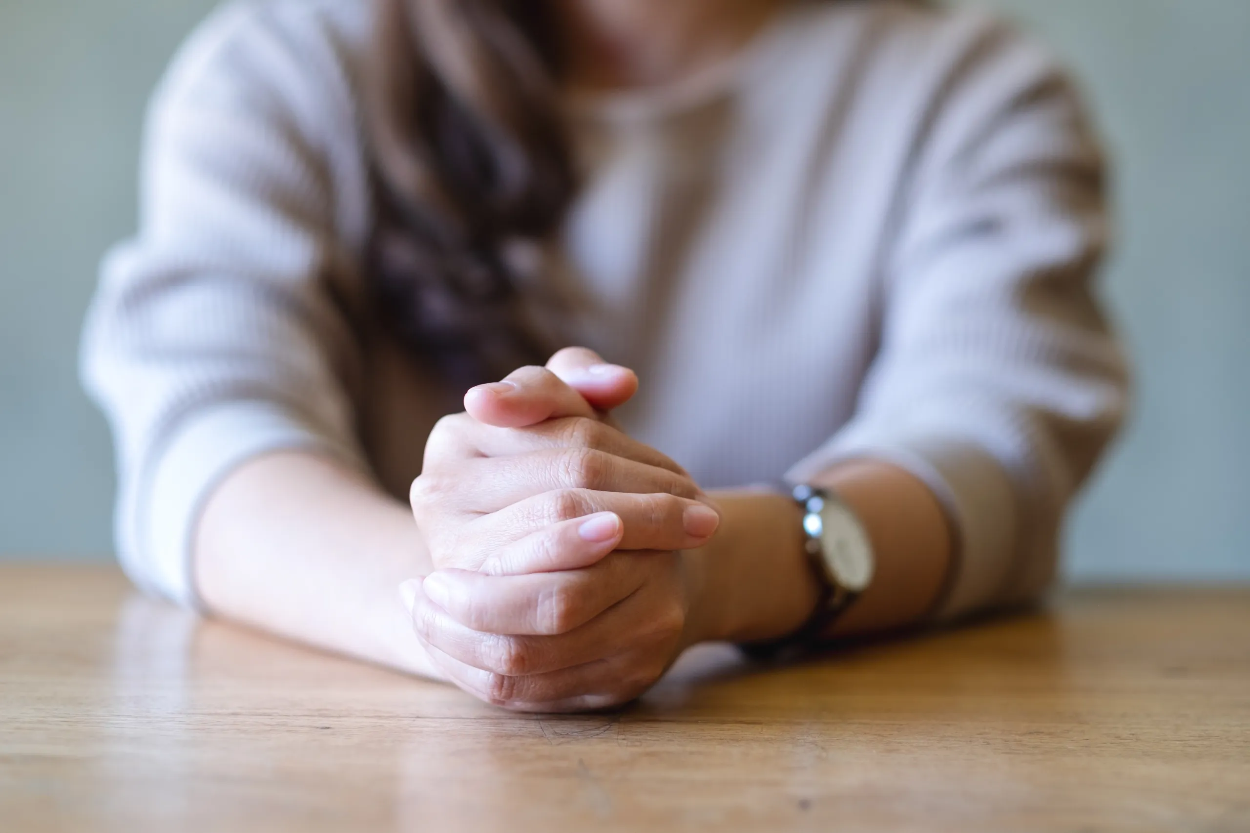 Mujer con ansiedad cruza las manos durante tratamiento para la ansiedad